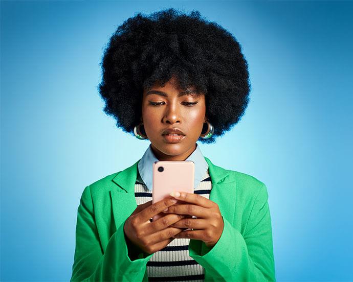 An image of a woman with black, chunky hair holding a pink phone case