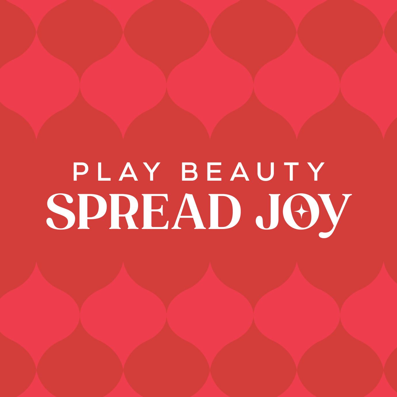 A red patterned graphic featuring the words “Play Beauty Spread Joy” in white, with bold, festive typography and a star accent inside the word “Joy.”