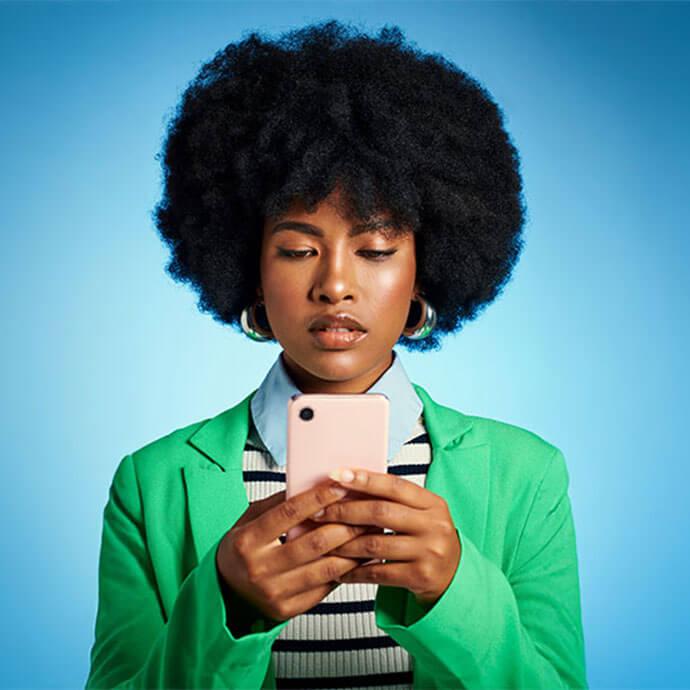 An image of a woman with black, chunky hair holding a pink phone case