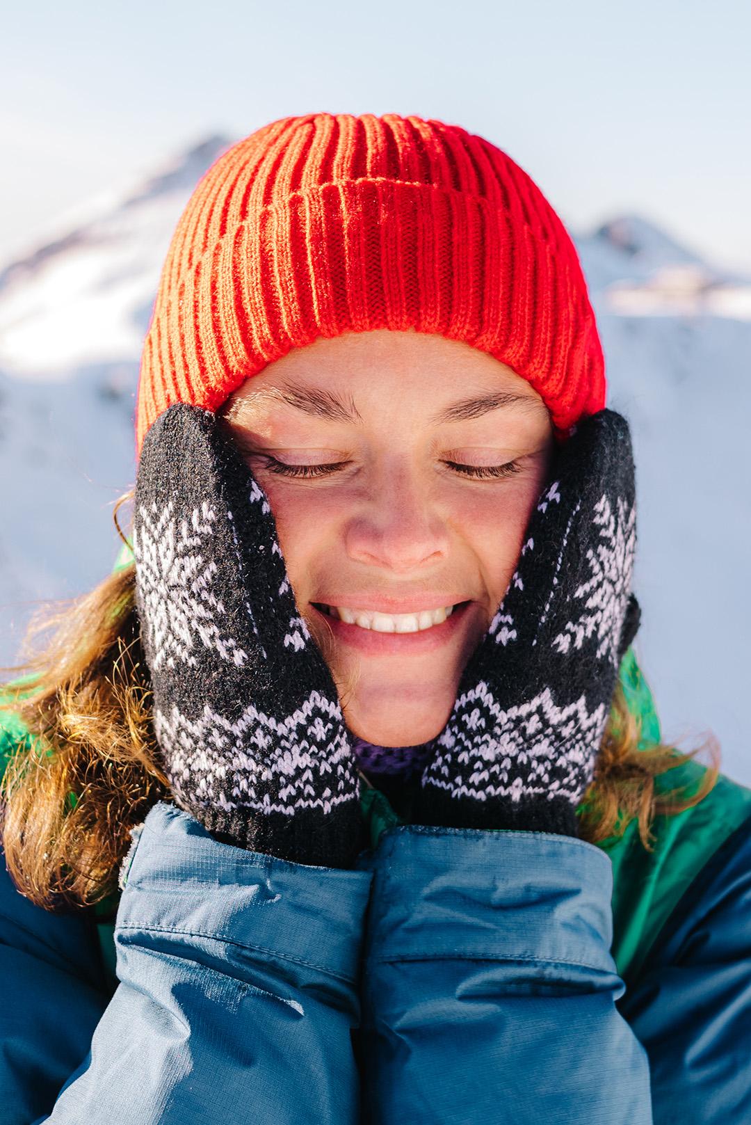 A photo of a woman touching her face on a snowy environment Desktop