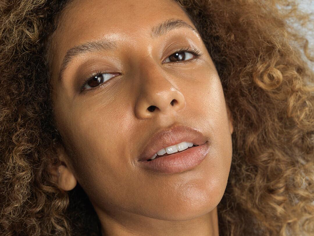 A closeup photo of a woman with dewy skin