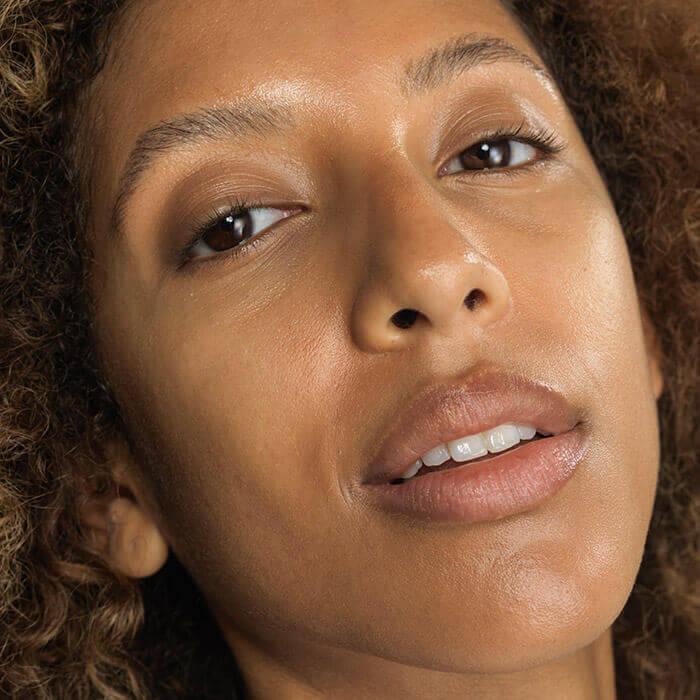 A closeup photo of a woman with dewy skin