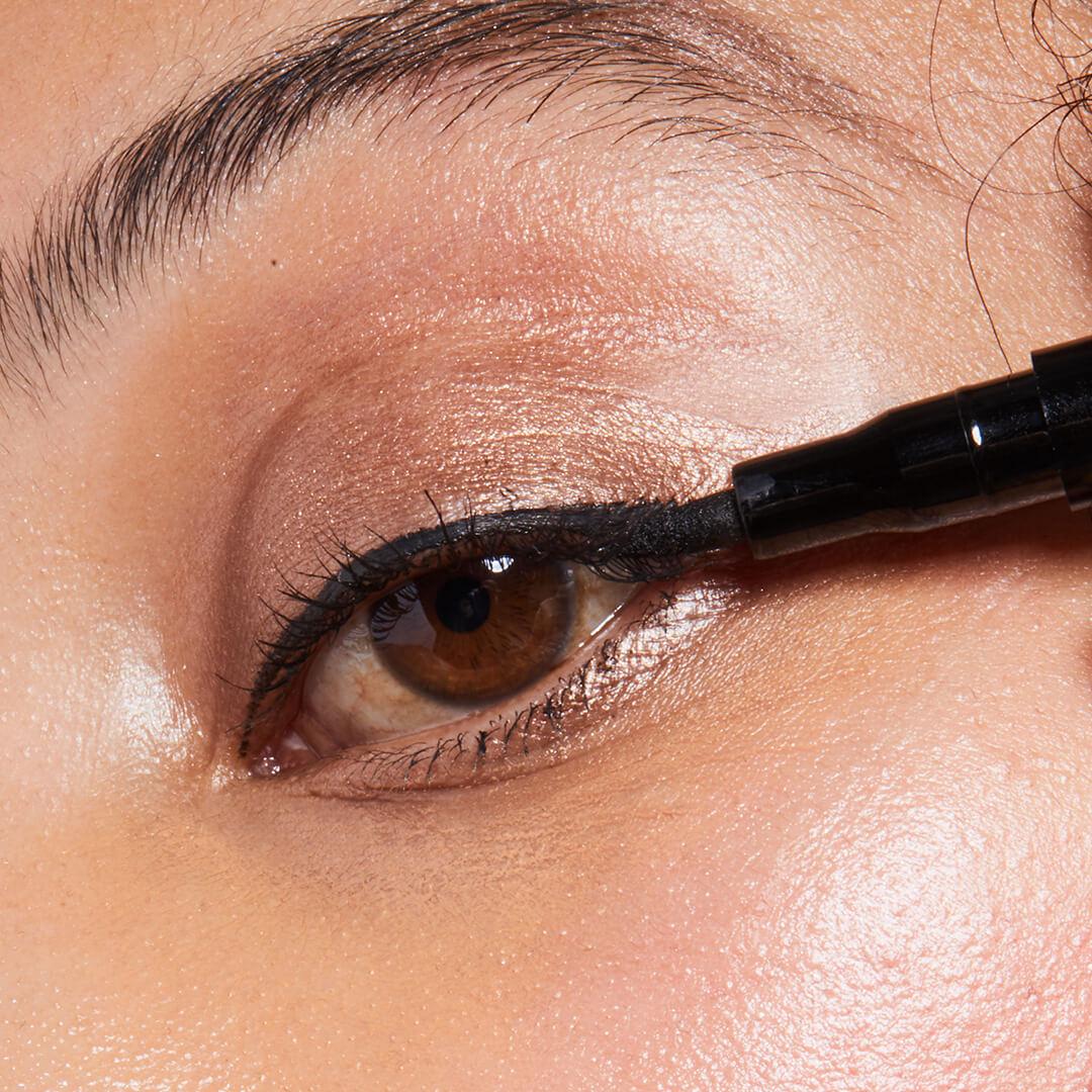 Close-up of woman putting eyeliner on her eyelid Mobile