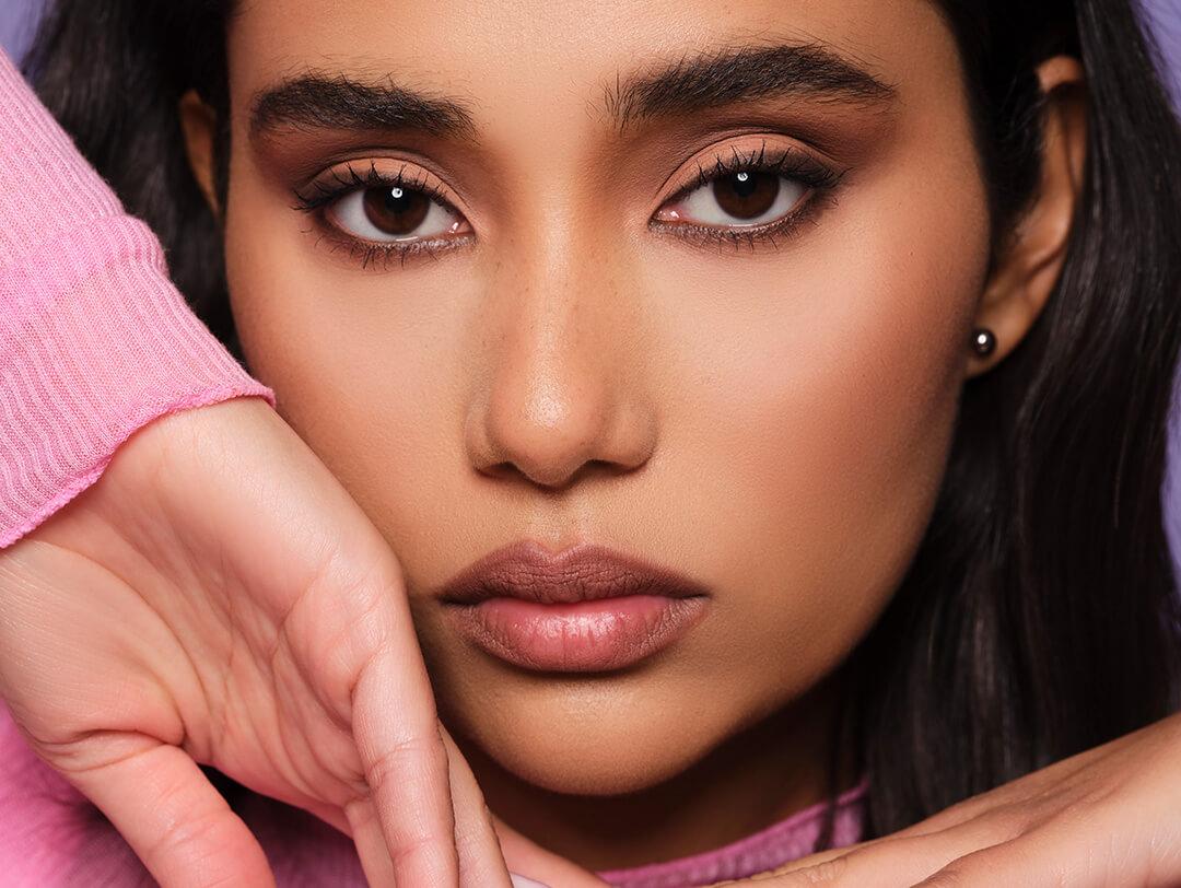 Close-up of a model posing and rocking a sultry neutral makeup look
