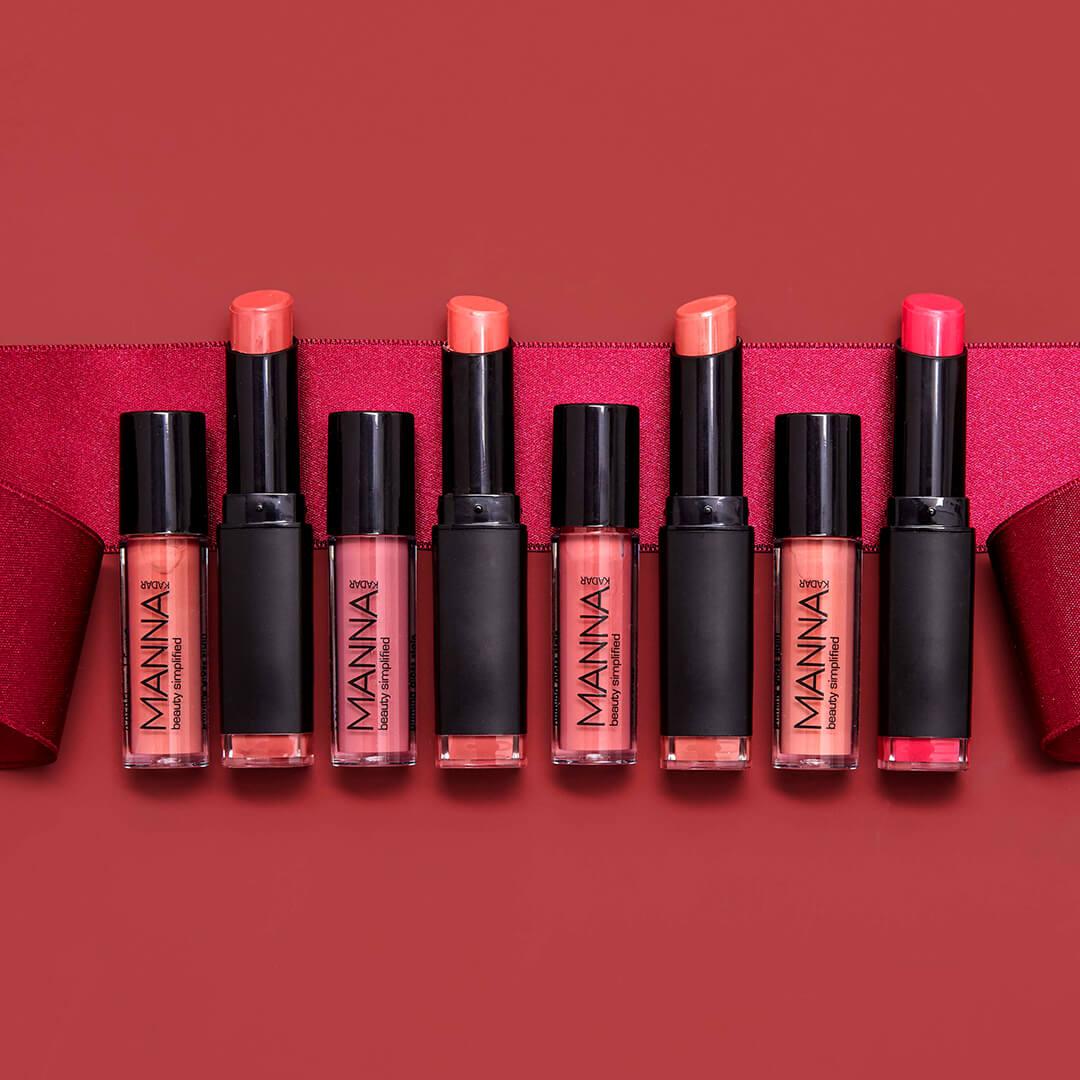 A photo of different shades of MANNA KADAR COSMETICS Lipsticks on a red background with a ribbon Desktop