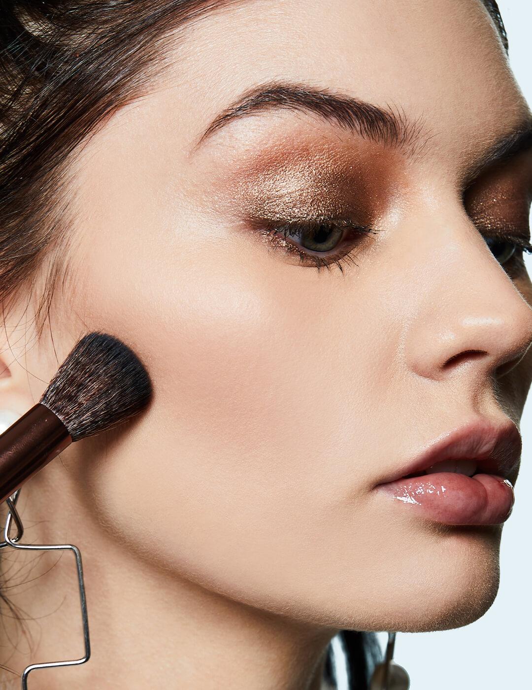 Close-up of a model applying contour below her cheeks Desktop