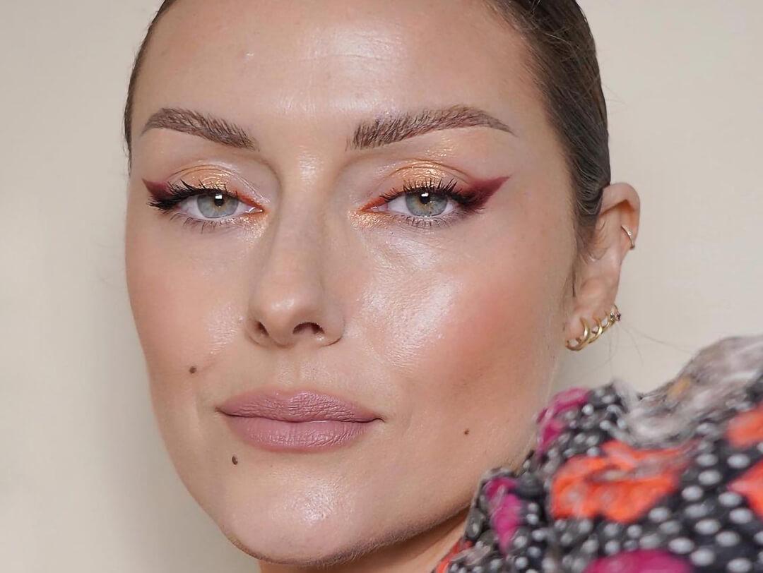 Close-up of a woman rocking a peachy glitter eye makeup look paired with nude lips Desktop