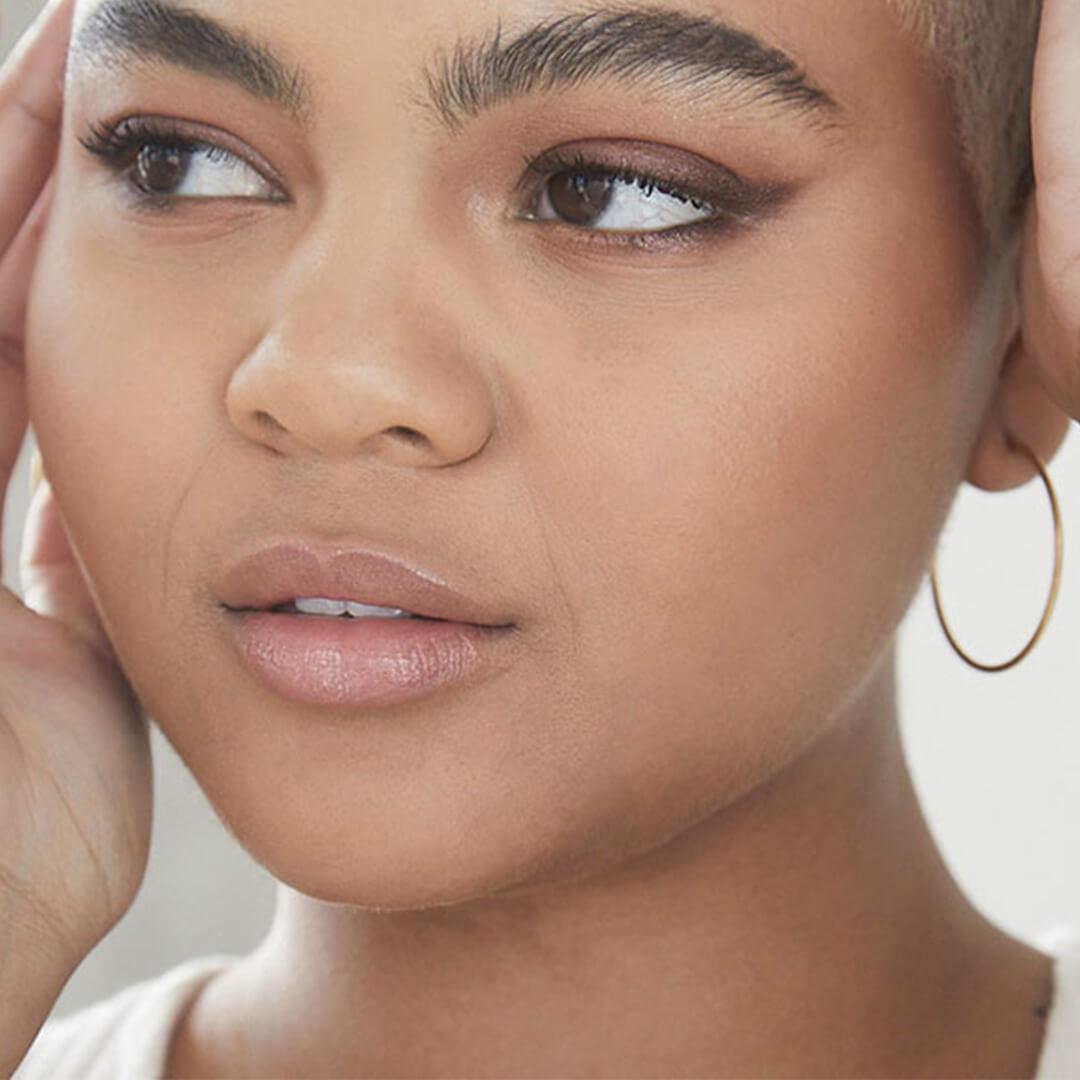 Close-up of a young woman rocking a neutral makeup look with winged eyeliner Desktop