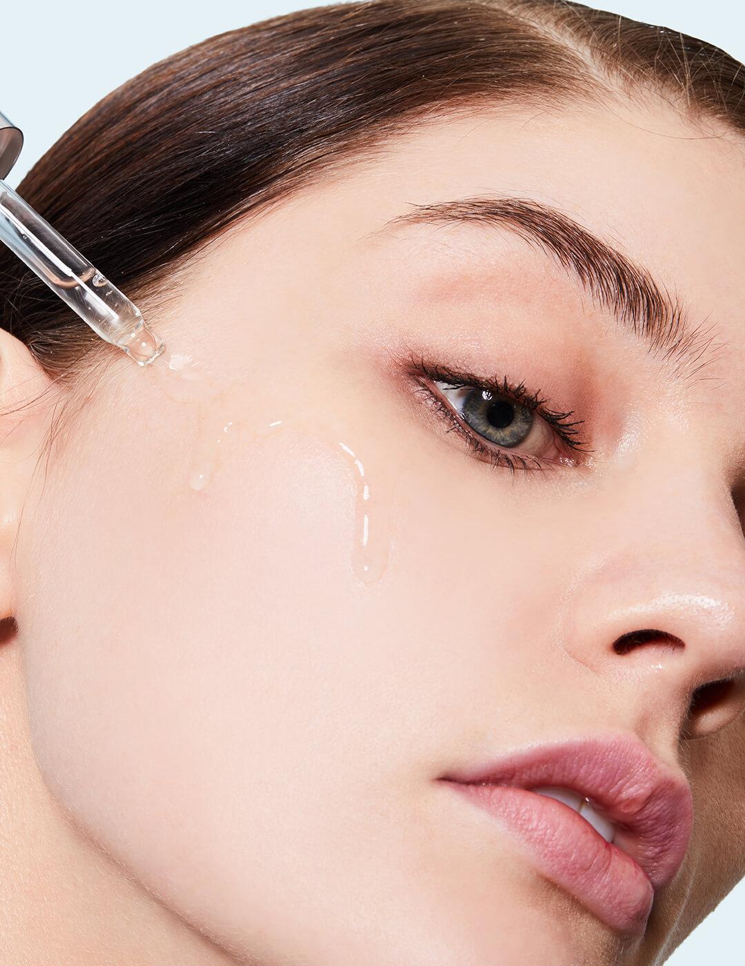 Close-up of a model applying serum on her cheeks Desktop