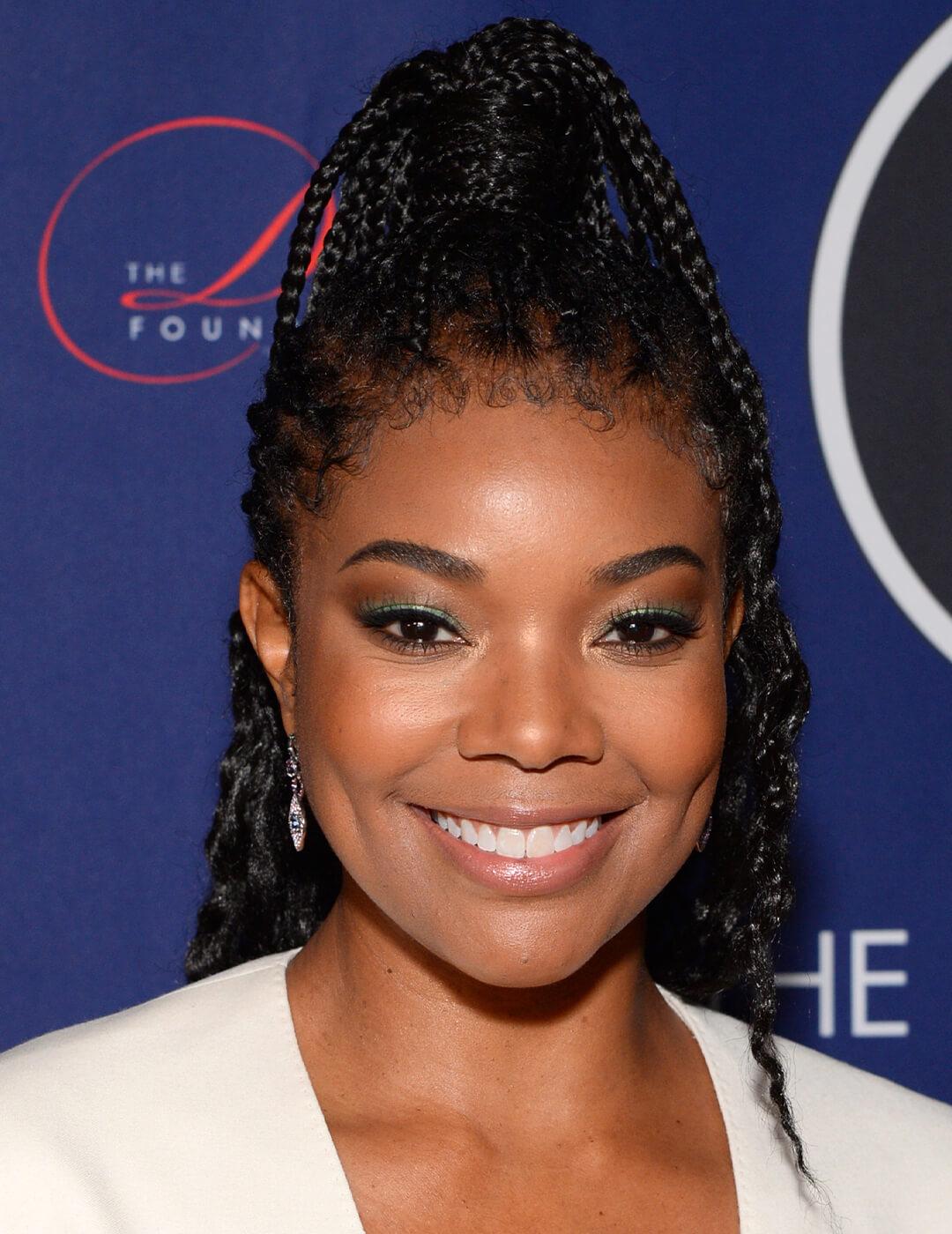 A photo of Jessica Alba showing off her back braided side ponytail looking in a camera Mobile