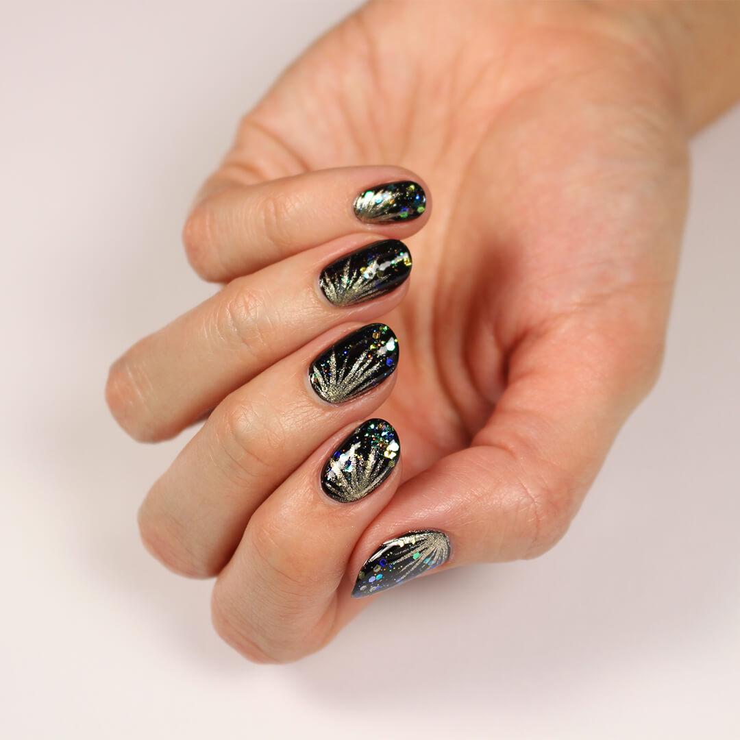 Image of a model's hand with a black, fireworks themed nail art mani Desktop