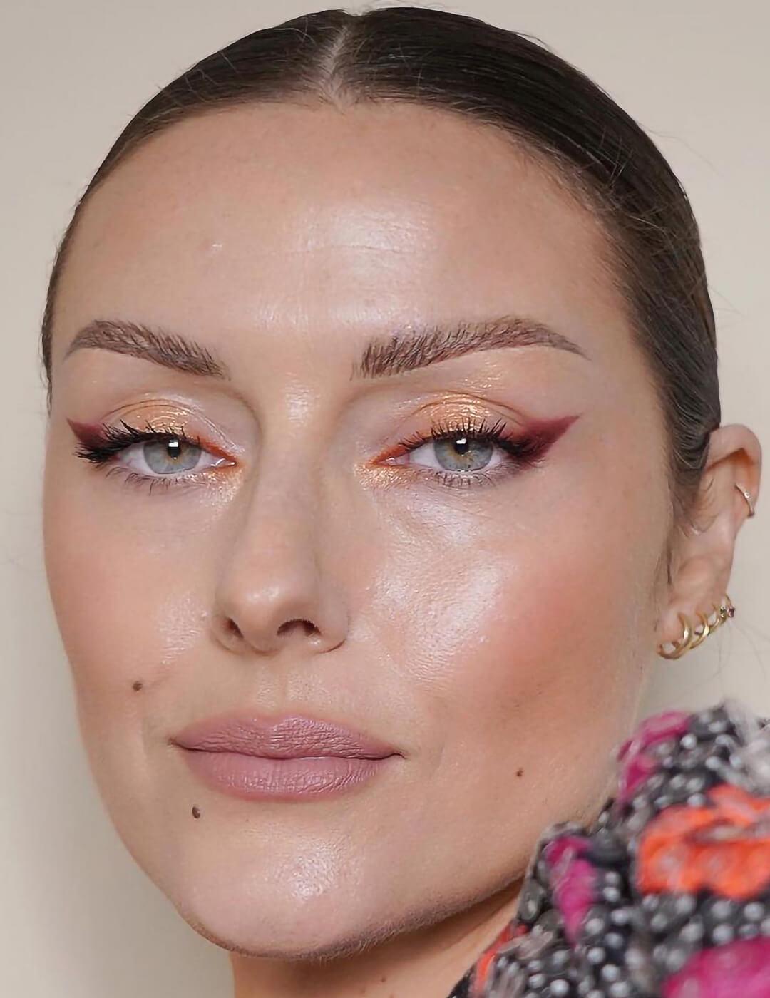 Close-up of a woman rocking a peachy glitter eye makeup look and nude lips Mobile