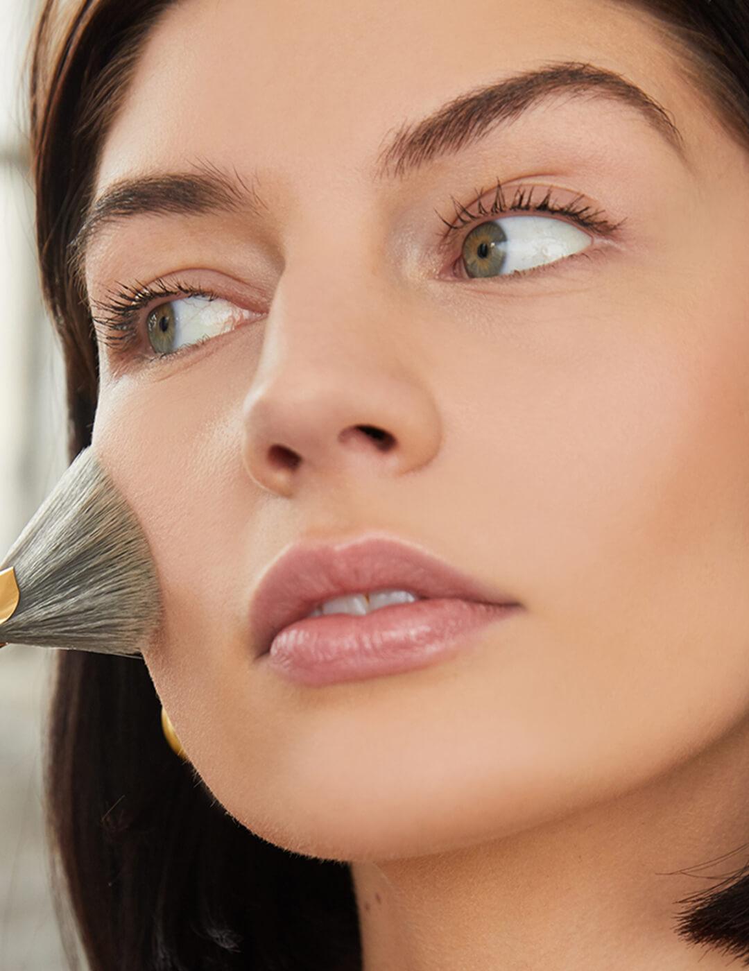 Close-up of a model applying blush on her cheeks Mobile
