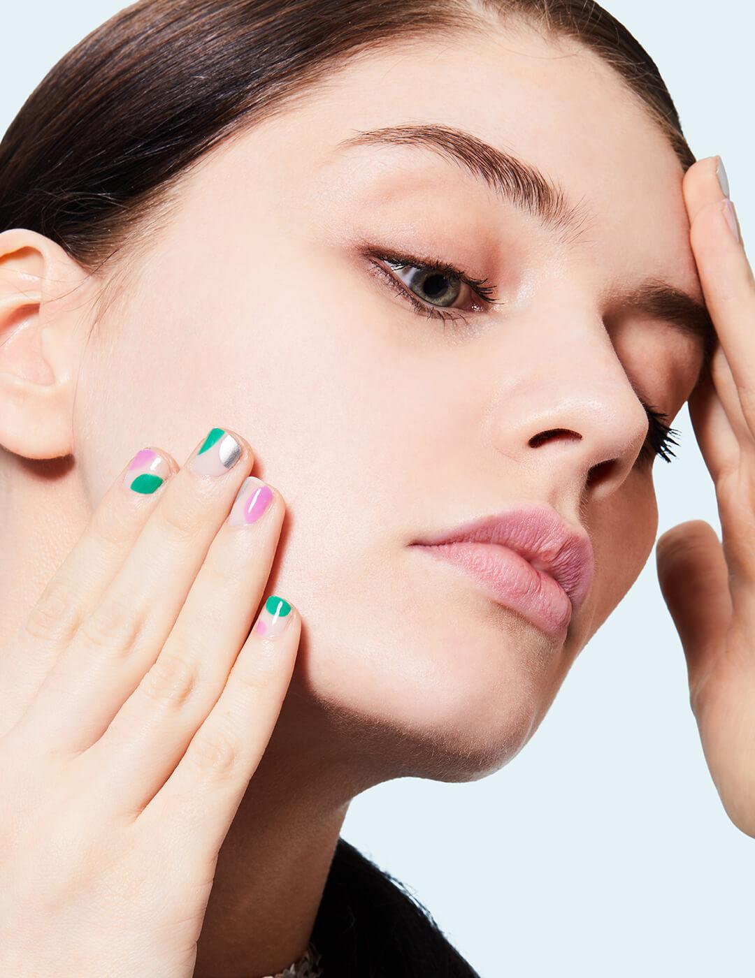Close-up of a model applying primer on her face using her hands Desktop