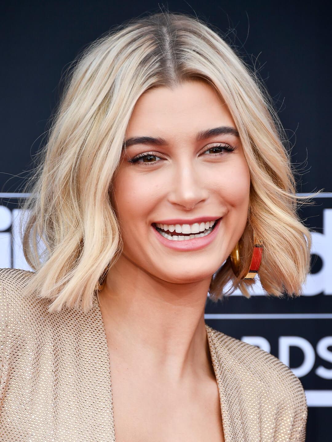 Hailey Baldwin rocking a wavy bob and gold dress Mobile