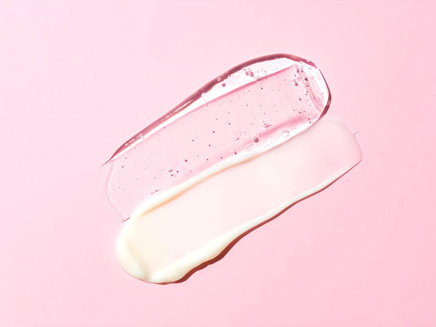 Two distinct skincare product textures, one a translucent gel and the other a smooth cream, are displayed against a pink backdrop Desktop