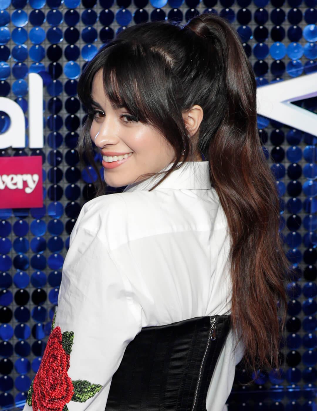 Camila Cabello rocking a white shirt with a rose print, black corsette, and high ponytail with bangs hairstyle Desktop
