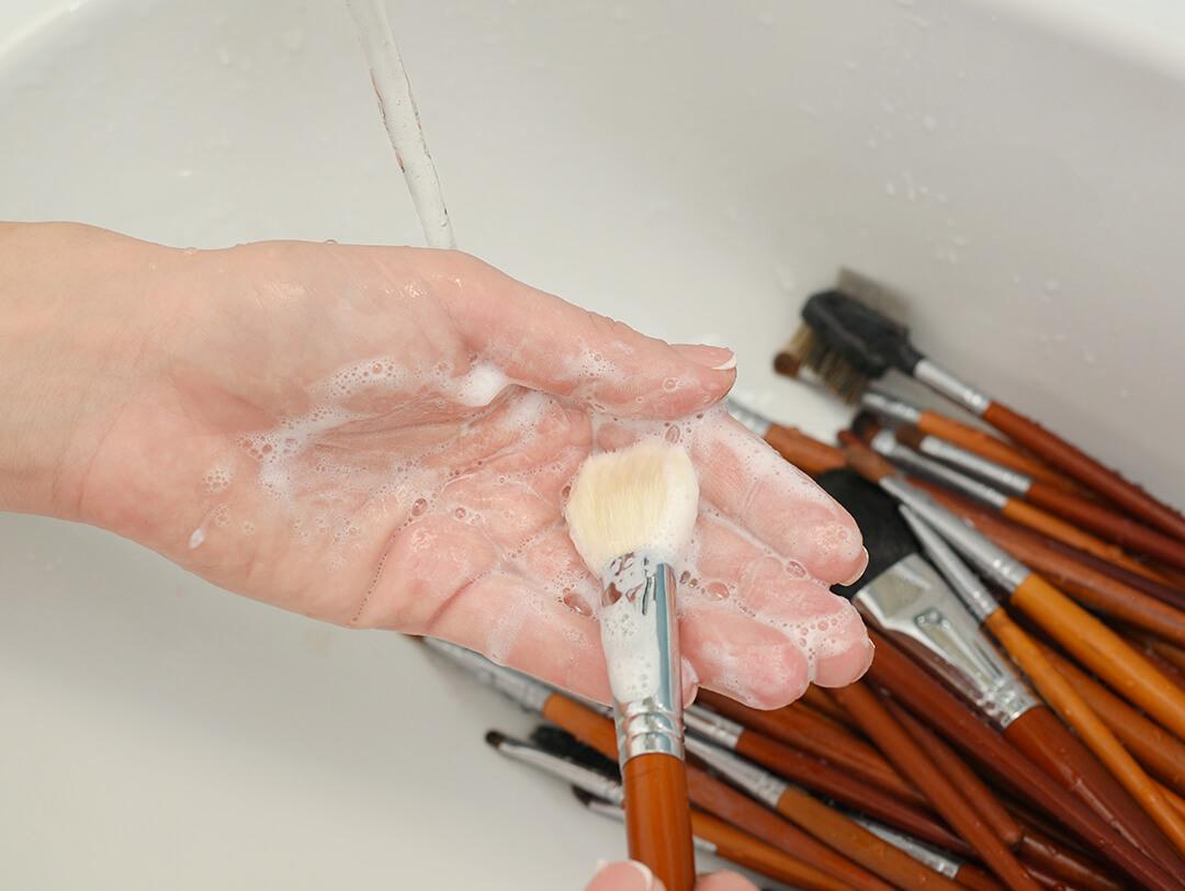 Close-up image of woman's hand cleaning brushes in the sink Desktop