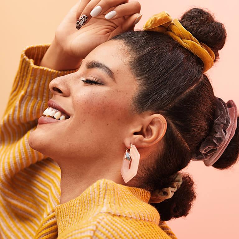 A model sporting a double bun hairstyle with scrunchees Mobile