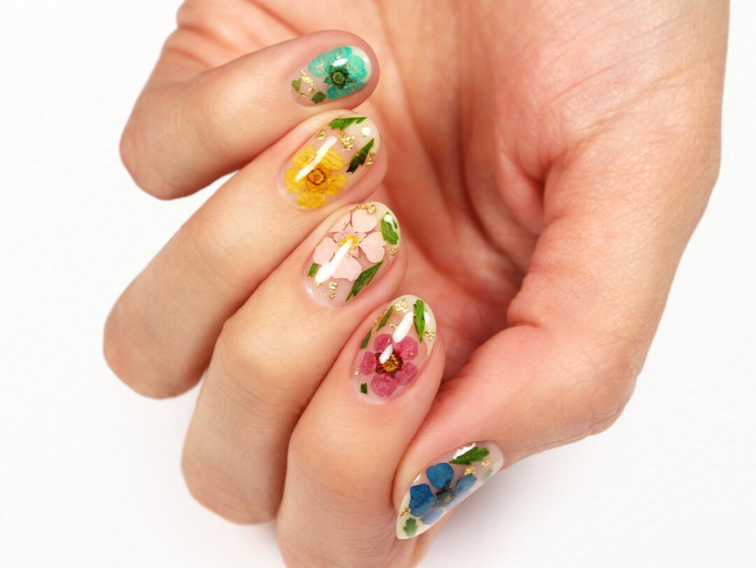 A close-up image of a model's hands with floral nail art Desktop