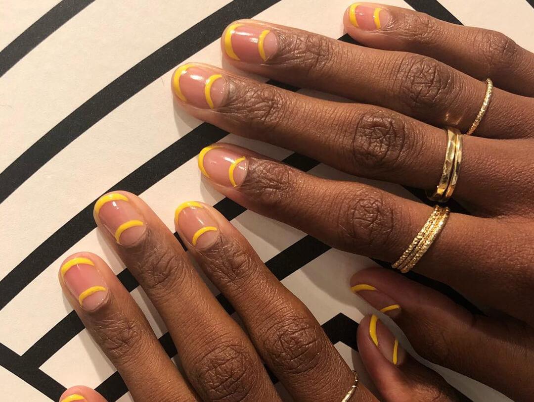 Close-up of a woman's hands with graphic, yellow nail art