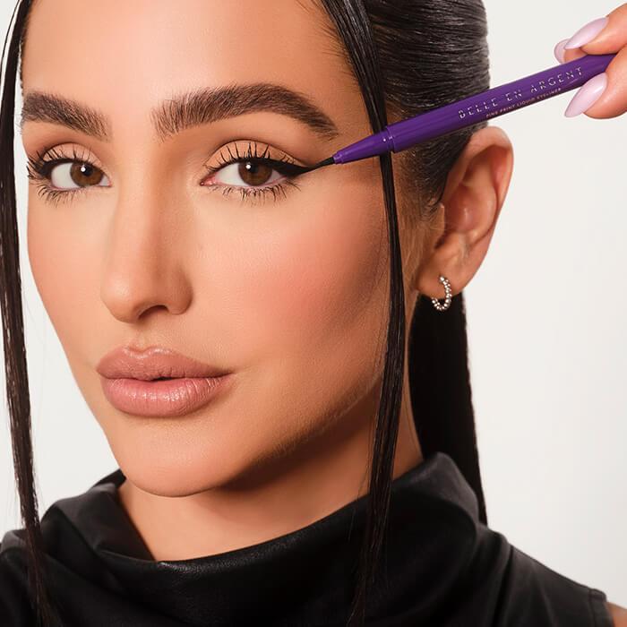 Close-up of Ash K Hom applying liquid eyeliner Mobile