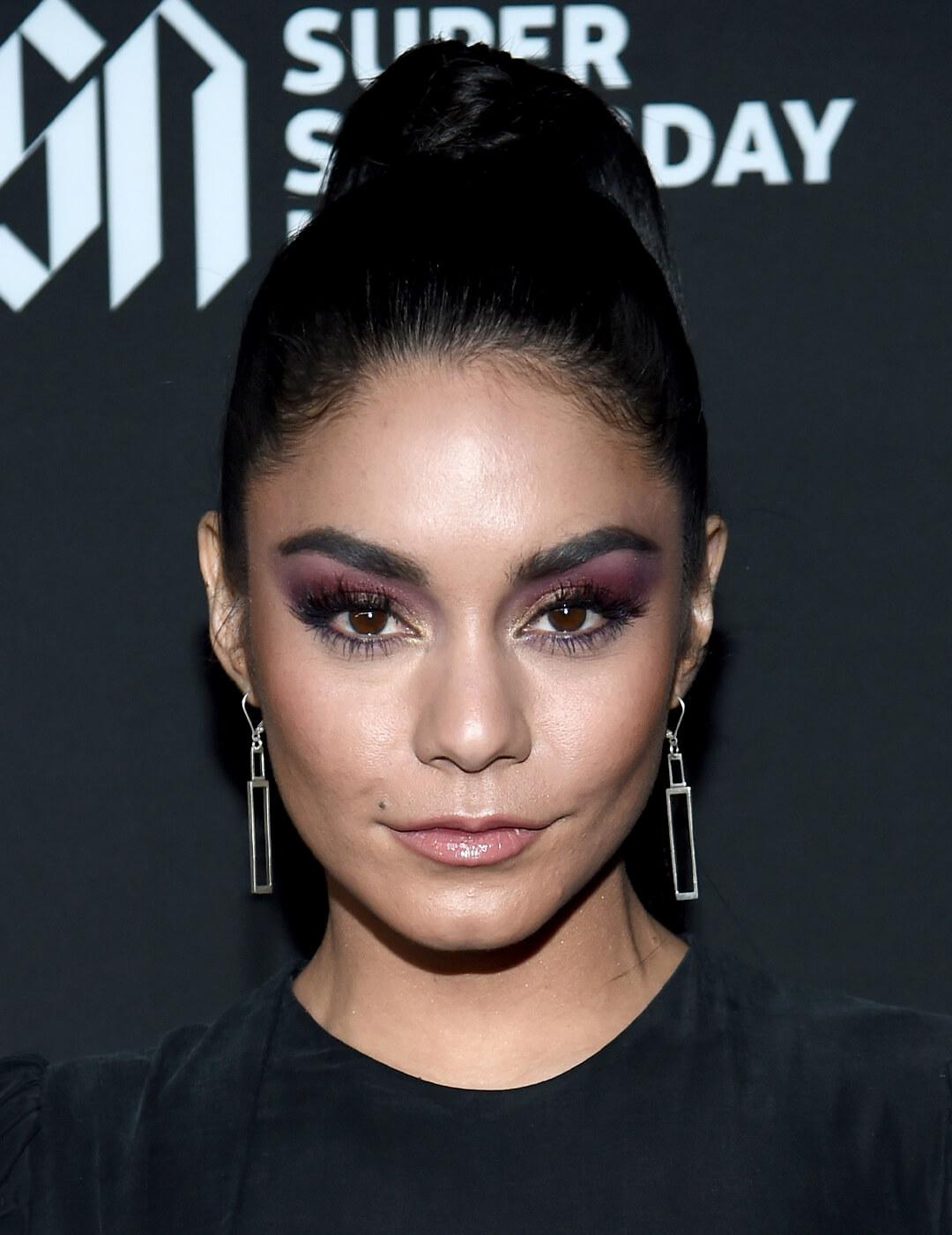 Vanessa Hudgens rocking a slick, high ponytail hairstyle and purple smoky eye makeup look Mobile