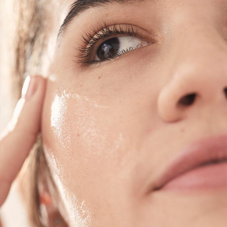 A model smiles while applying her primer