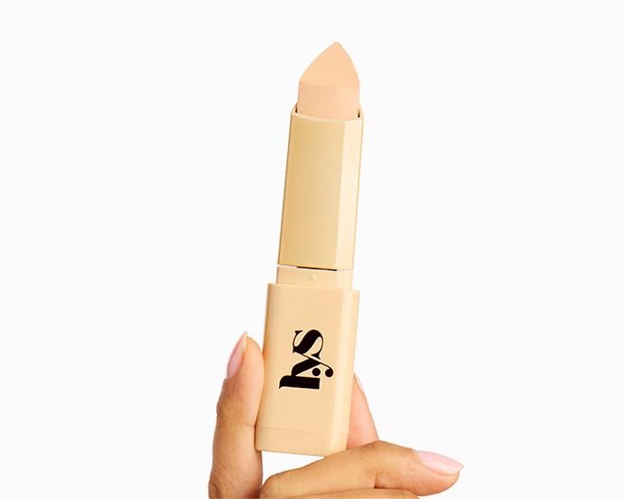 LYS Beauty Triple Fix Blurring Skin Tint Foundation Stick held in hand, showing a creamy complexion stick designed for buildable coverage and a natural, blurred finish.