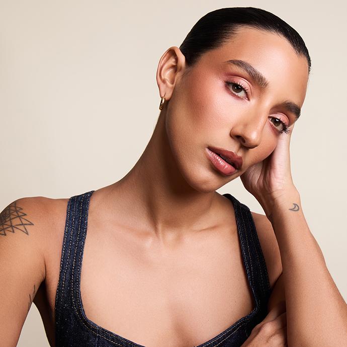 Model with smooth, radiant skin and softly sculpted makeup, highlighting a flawless, pore-blurring base that showcases the return of primer