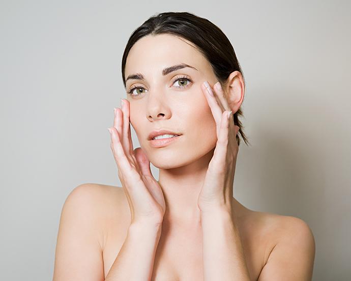 Young woman touching face