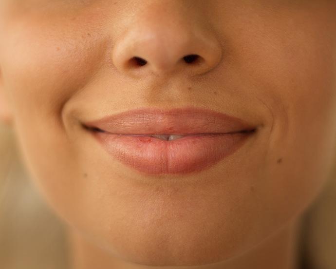 Close up face lips of unrecognizable Indian Arabian woman girl female lady smiling smile sensuality plastic surgery beauty lipstick make up health medicine cropped view indoors feminine cosmetology