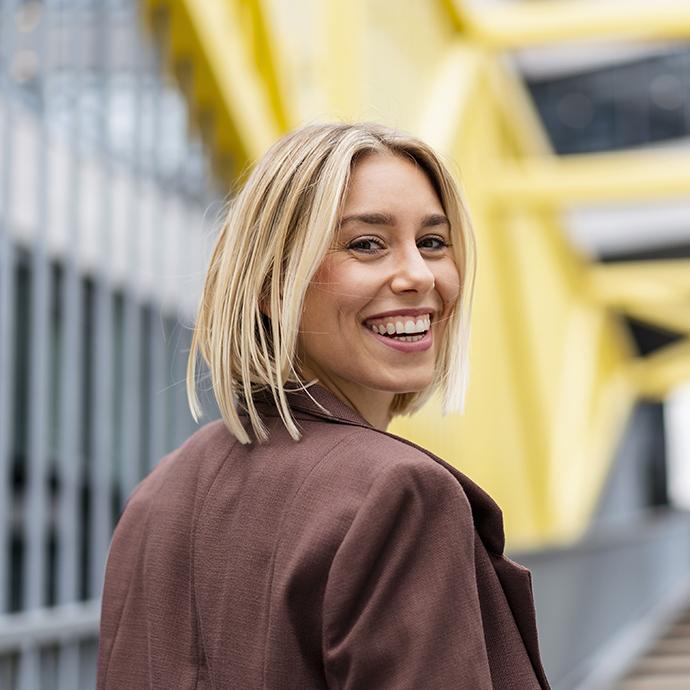 Portrait of happy young businesswoman on a bridge in the city