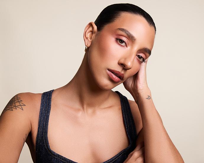 Model with smooth, radiant skin and softly sculpted makeup, highlighting a flawless, pore-blurring base that showcases the return of primer