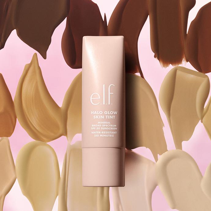 Product image of e.l.f. Halo Glow Skin Tint SPF 50 sunscreen tint, featuring a lightweight complexion product with broad-spectrum sun protection against a backdrop of blended skin-tone swatches.