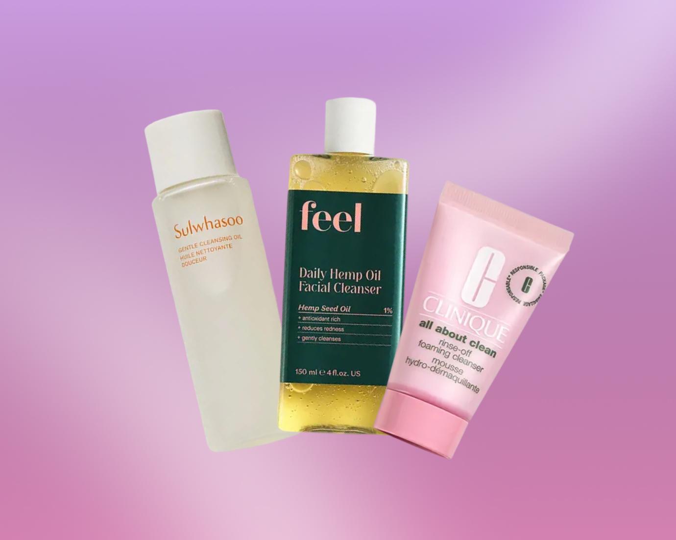Three facial cleansers used for double cleansing—a Sulwhasoo gentle cleansing oil, a Feel Daily Hemp Oil Facial Cleanser, and a Clinique All About Clean foaming cleanser—arranged against a soft pink-to-purple gradient background.