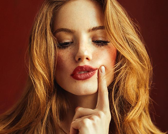 Young suspicious woman with long red hair