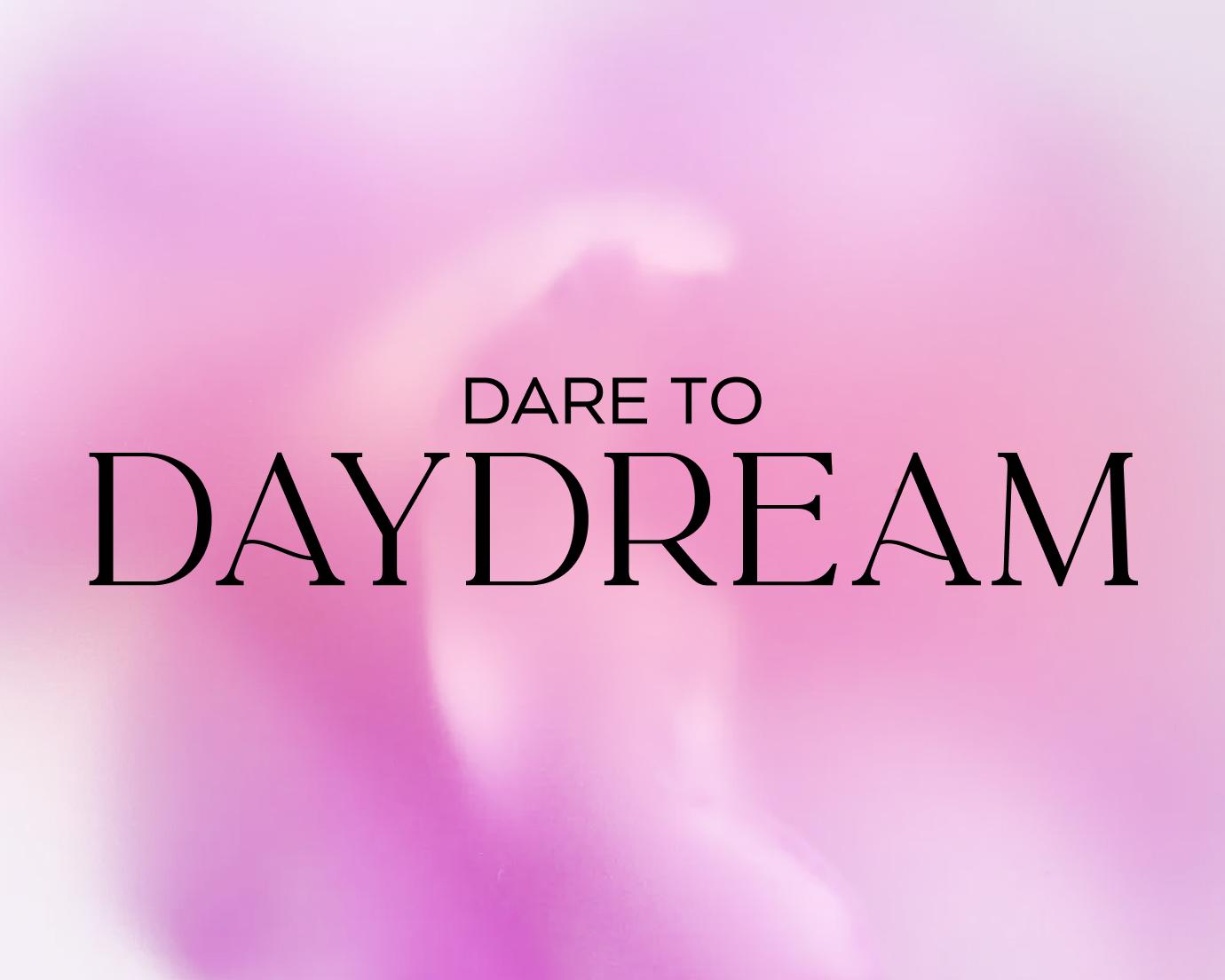 Dare to Daydream text over pink watercolor background, representing whimsical spring beauty theme and soft-focus glow