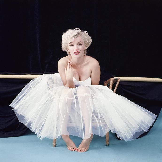 Archival portrait of Marilyn Monroe showcasing her signature platinum curls, winged eyeliner, luminous skin, and classic red lip—an iconic beauty look that continues to inspire timeless glam.
