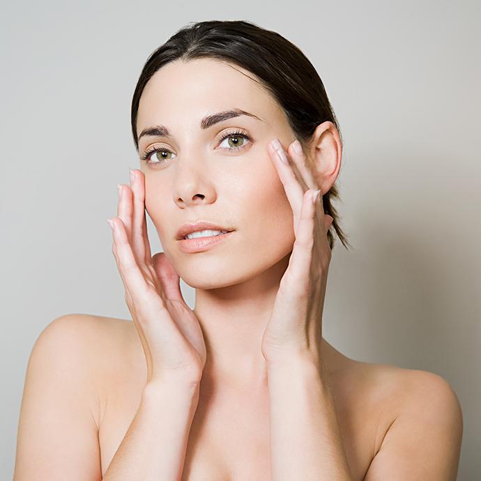 Young woman touching face