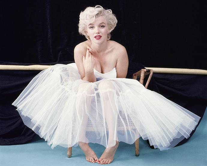 Archival portrait of Marilyn Monroe showcasing her signature platinum curls, winged eyeliner, luminous skin, and classic red lip—an iconic beauty look that continues to inspire timeless glam.