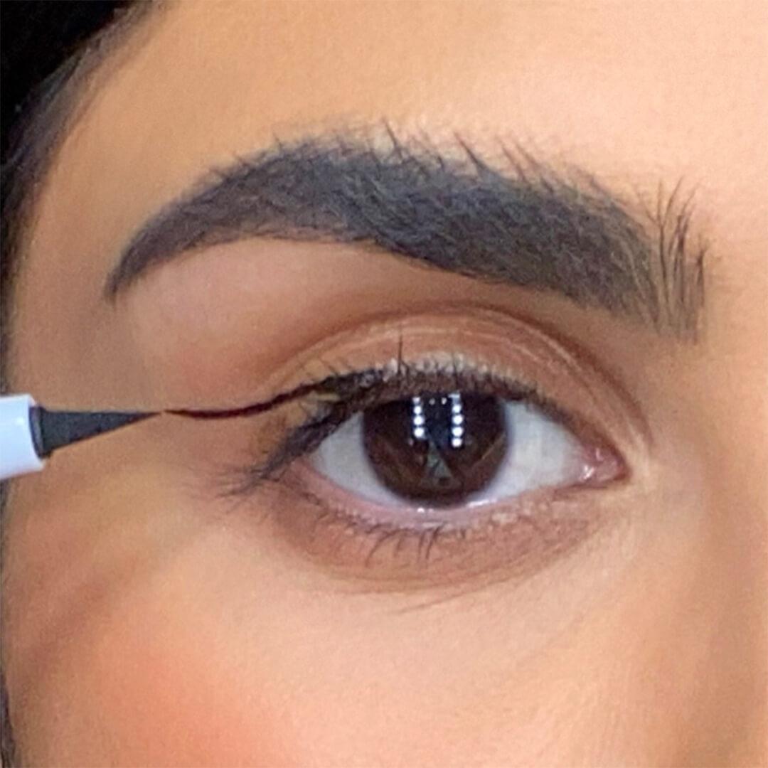 Close-up of a woman drawing a line on her eyelid with an eyeliner Desktop
