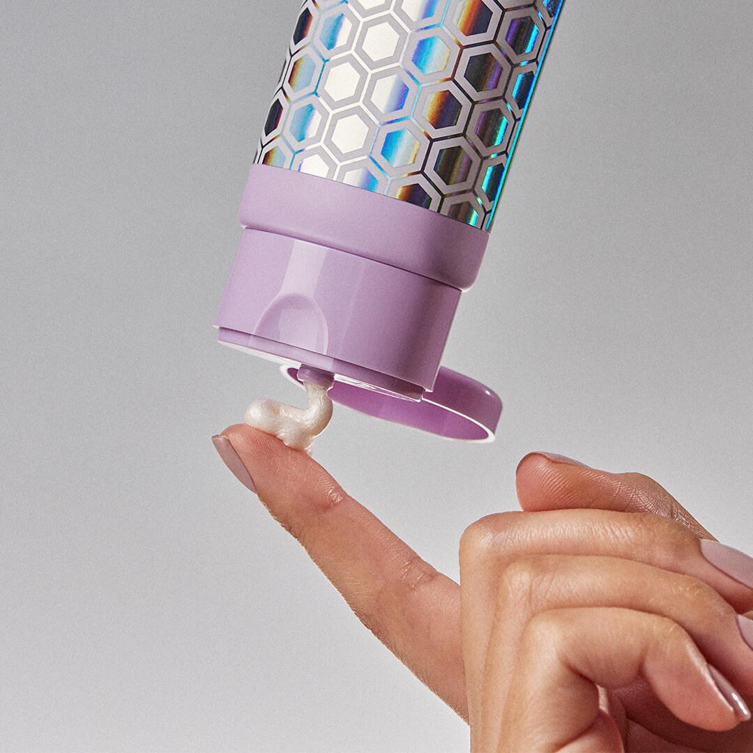 Close-up of a model squeezing a bit of lotion on her finger Mobile
