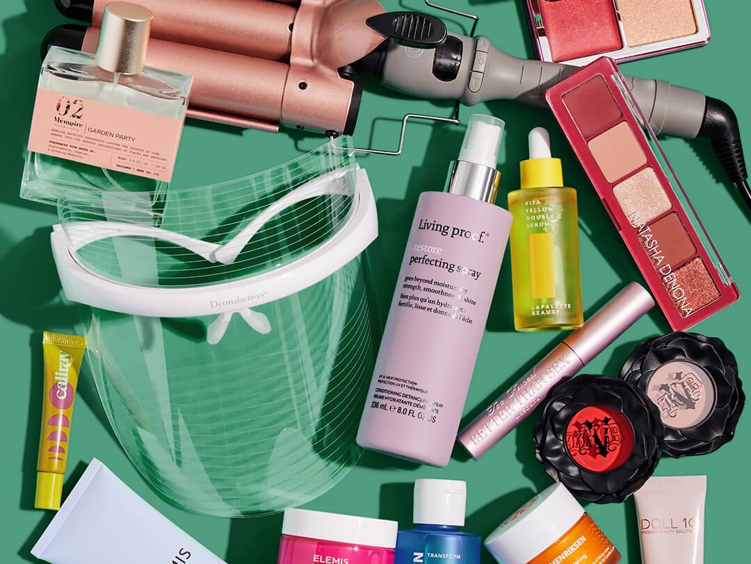 Makeup, skincare, and beauty products and tools from various brands scattered on green background Desktop