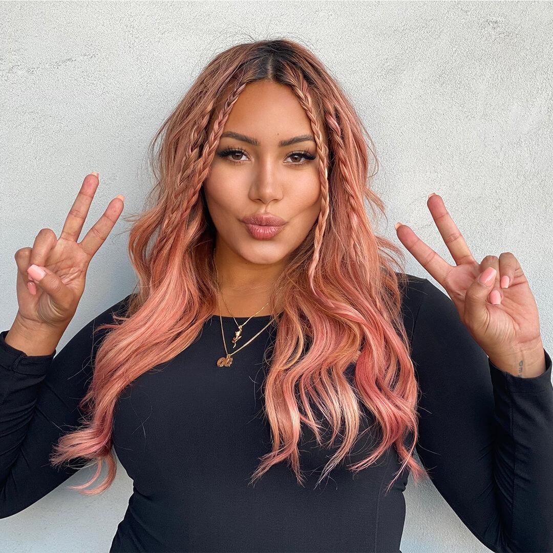 Model with pink hair posing with peace signs against concrete wall Mobile