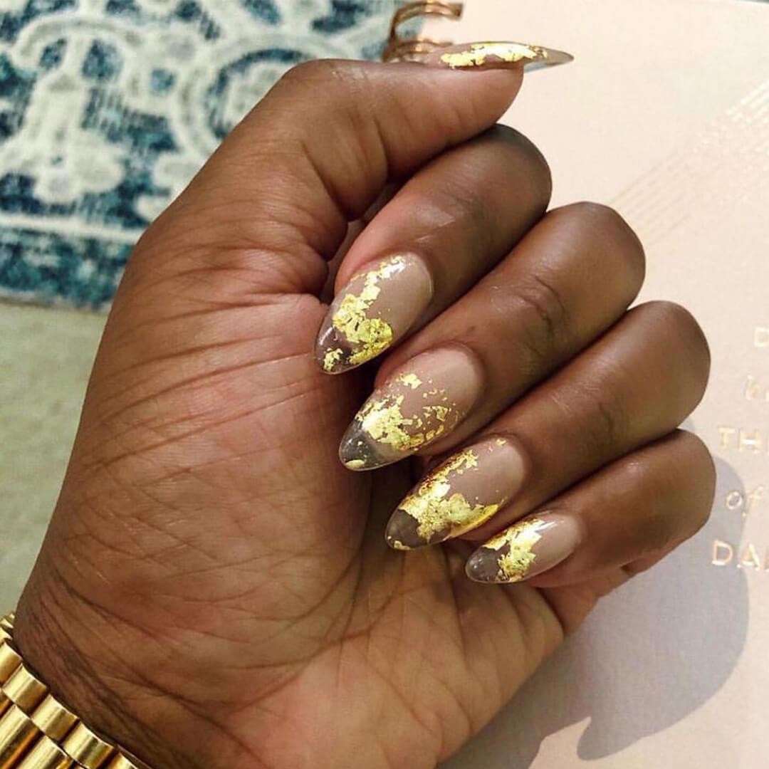 Close-up of a woman's hand with gold foil ombré nail art Mobile
