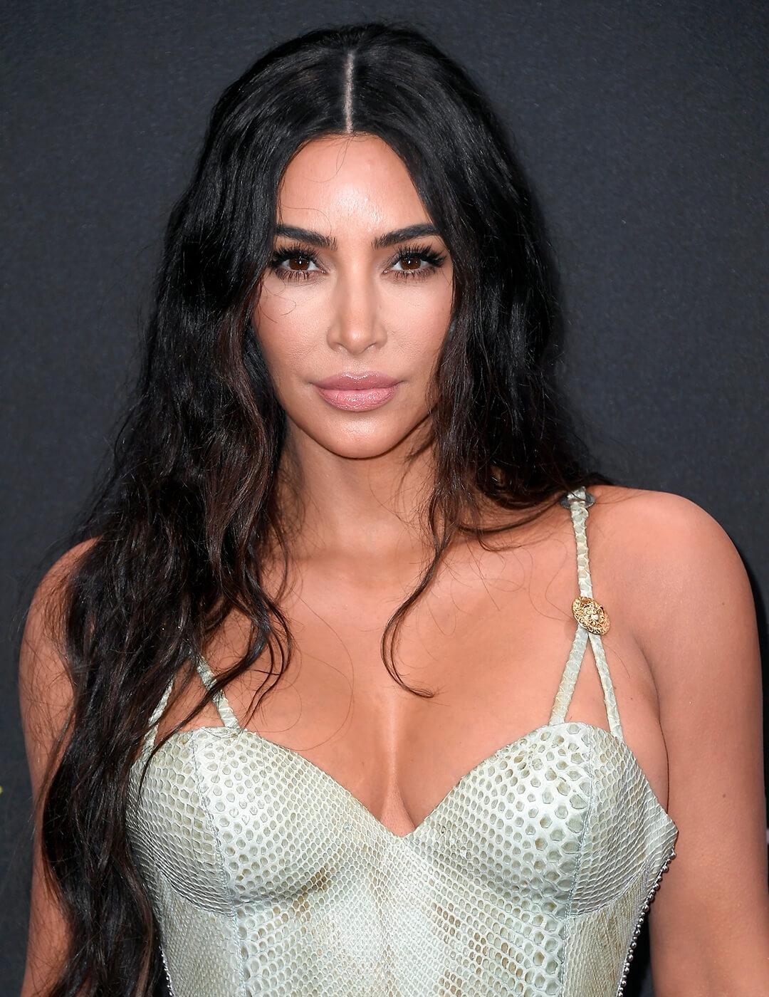 Kim Kardashian looking sexy in a faux snake skin dress and long, black wavy hairstyle Desktop