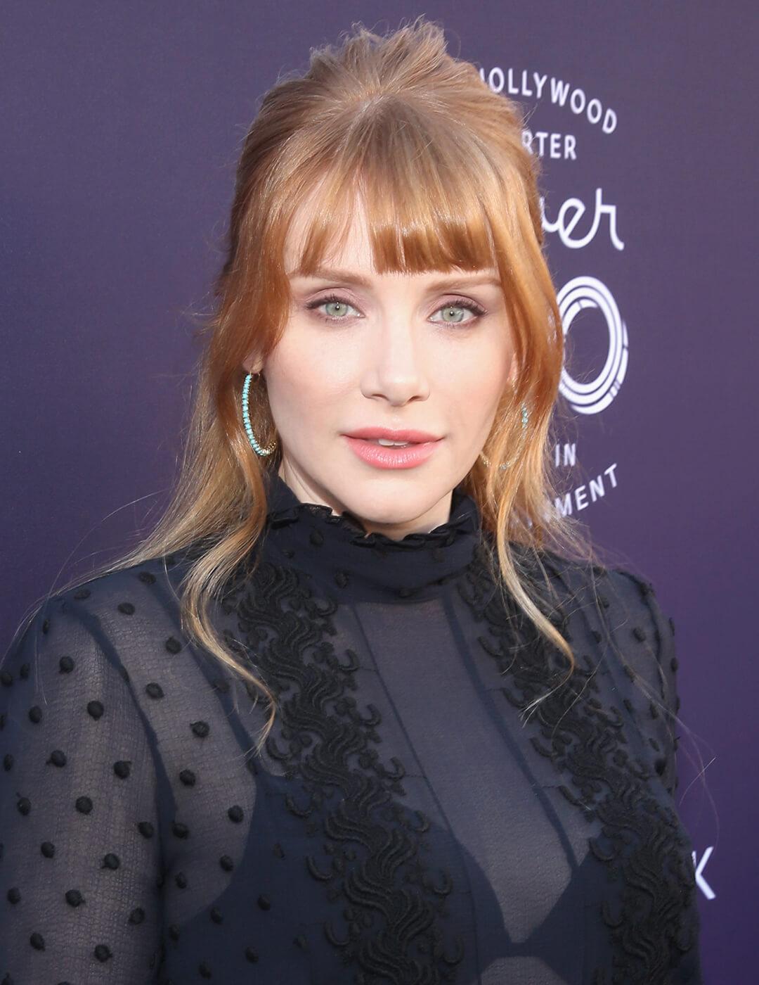 A photo of Bryce Dallas Howard with golden blonde hair and a light copper shade, wearing Mobile
