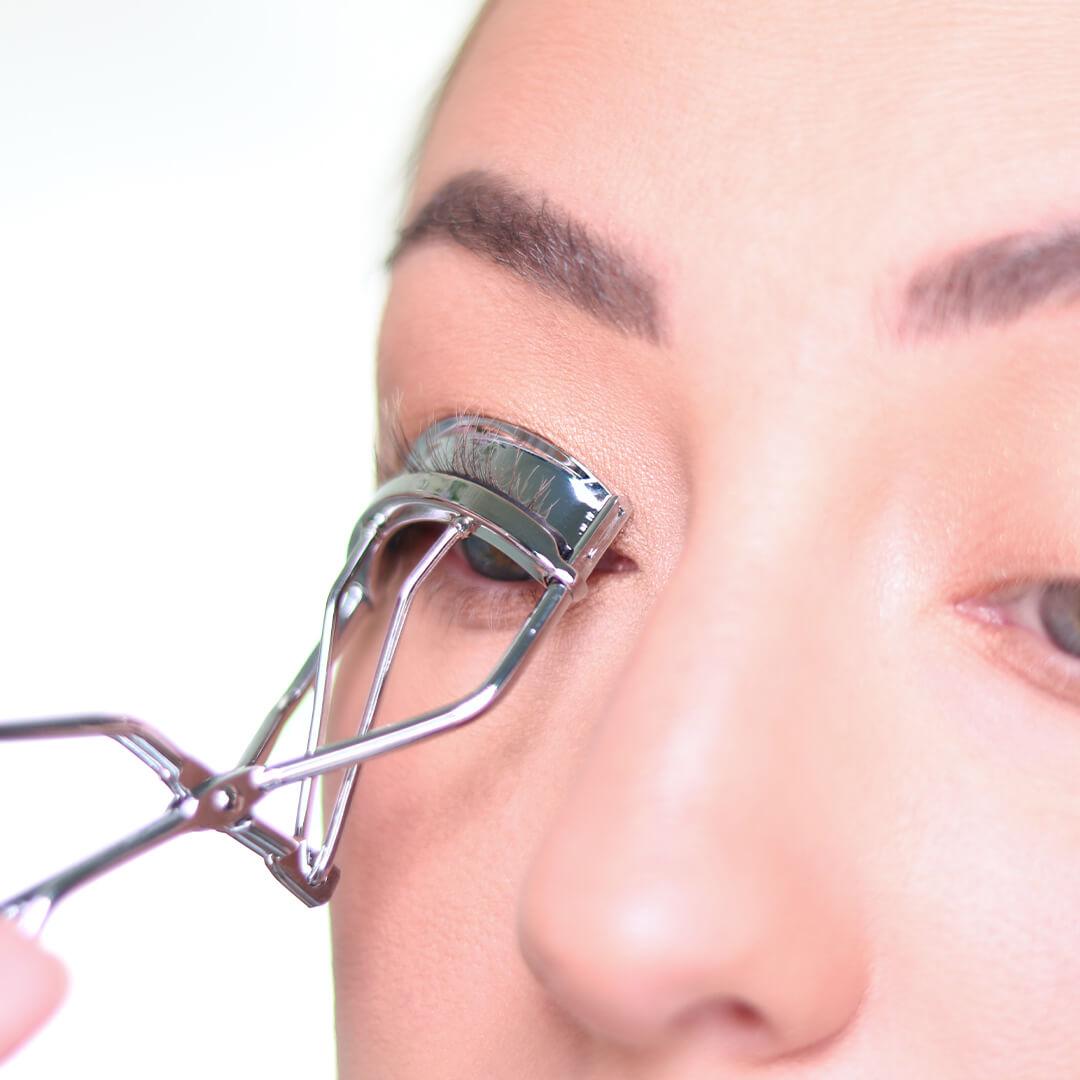 Close-up image of Anne Baker curling her lashes Desktop