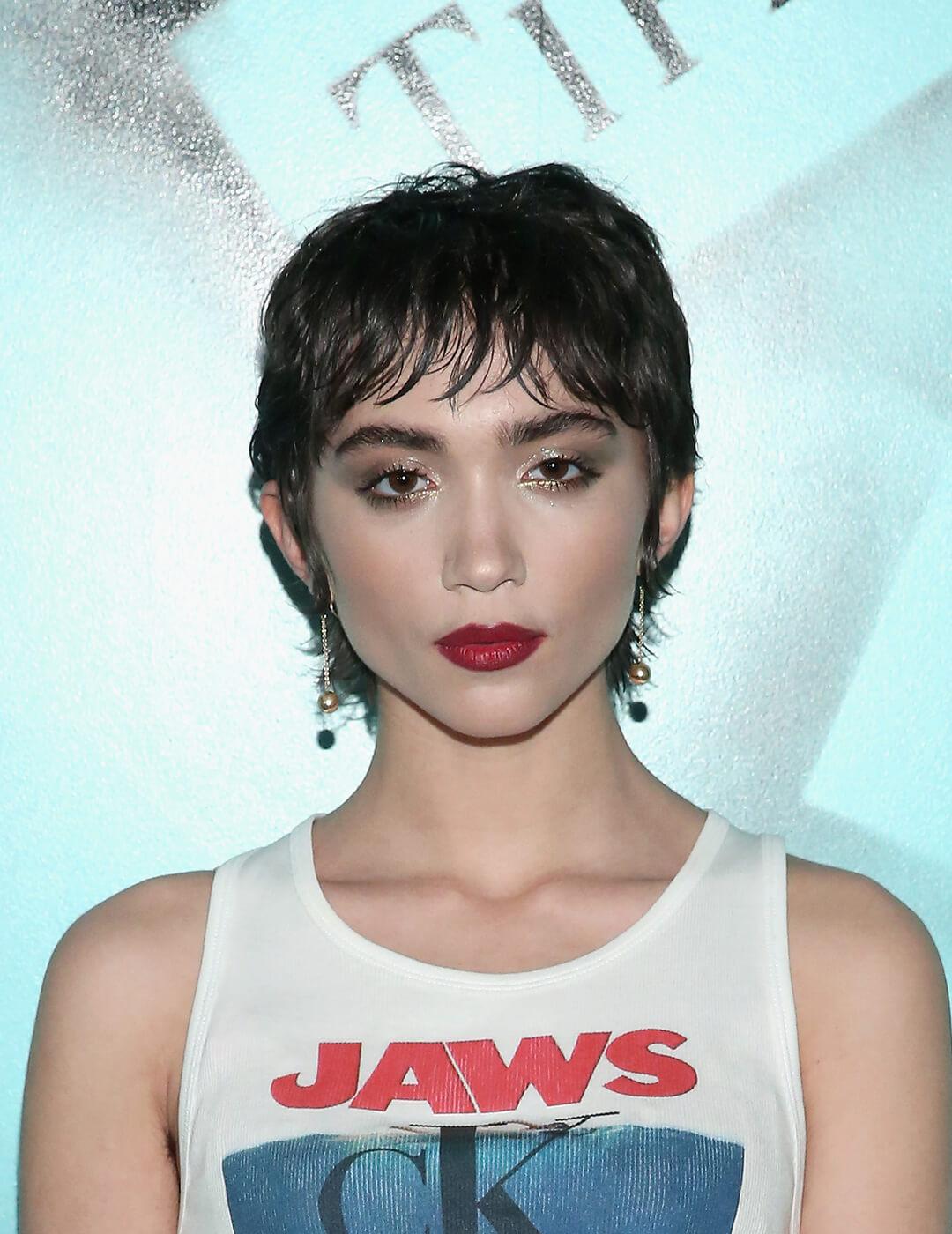 A photo of Rowan Blanchard wearing a Jaws printed crop top in her black short mullet Mobile